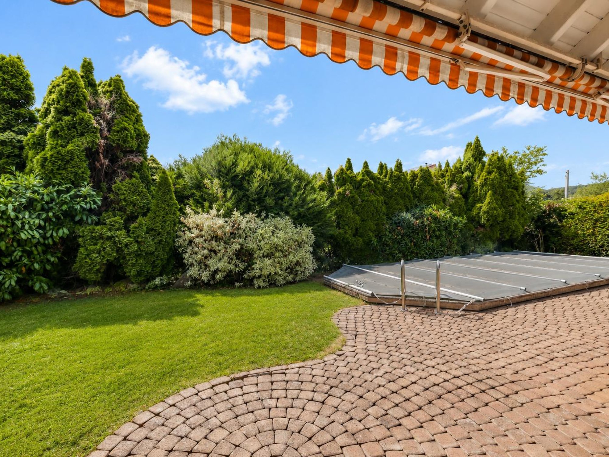 Blick in Garten vom gedeckten Sitzplatz