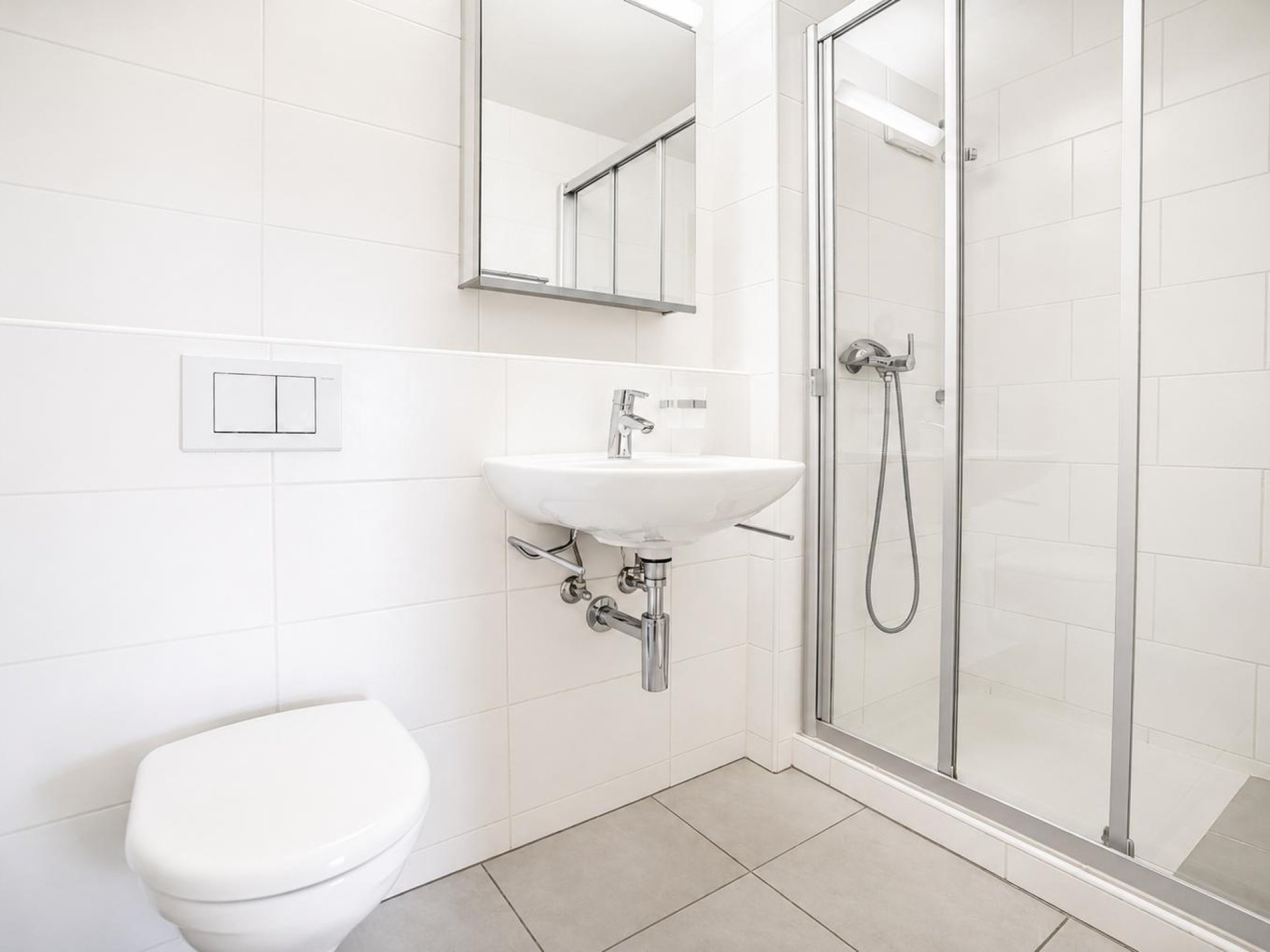 Badezimmer mit Dusche, Toilette und Lavabo