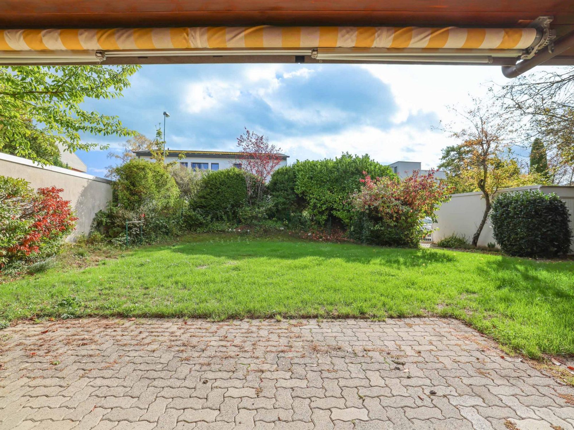 Blick in Garten vom gedeckten Sitzplatz